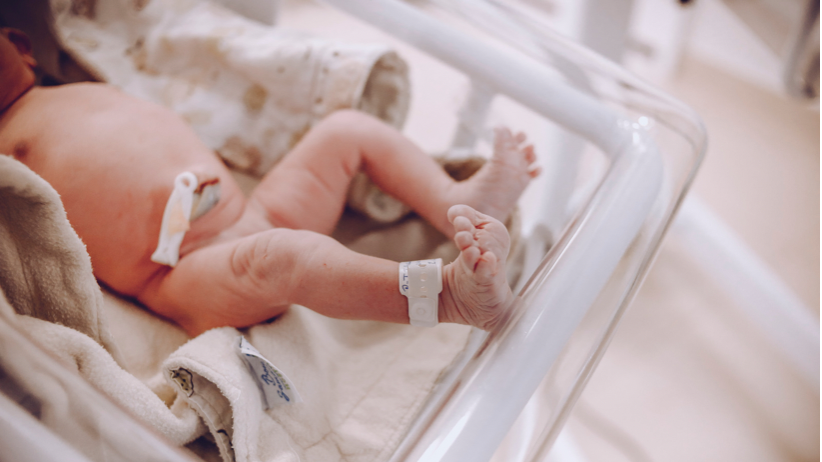 newborn baby in bassinet in hospital