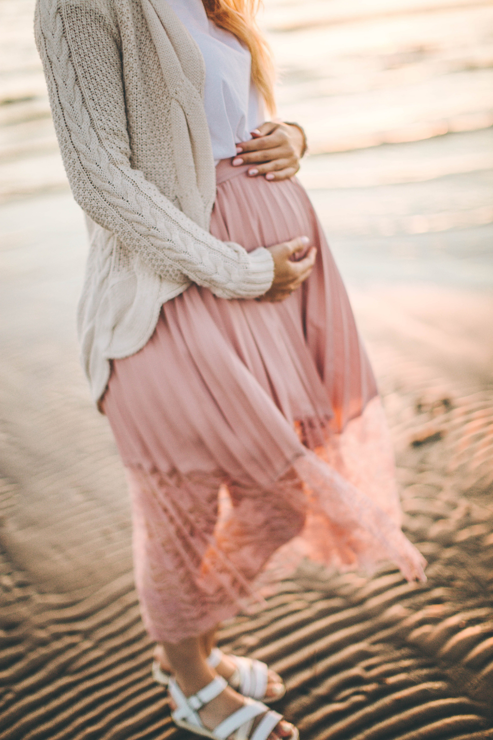 pregnancy woman in pink dress on the beach
