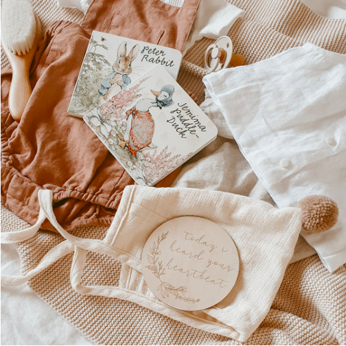 baby items and etched wooden milestone card