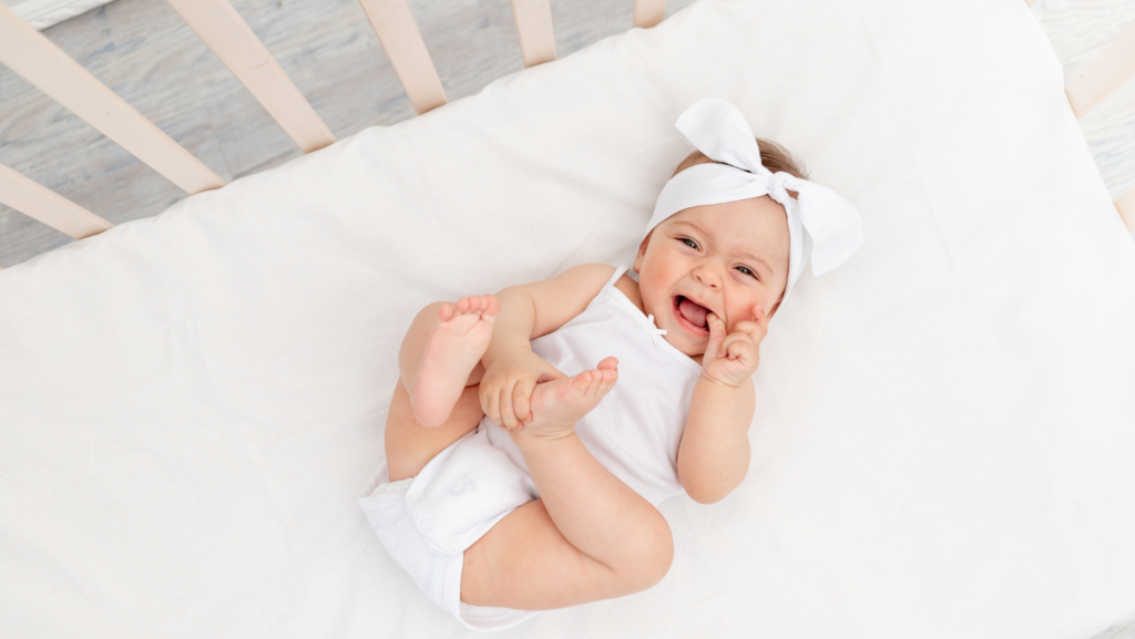 baby girl smiling laying in crib