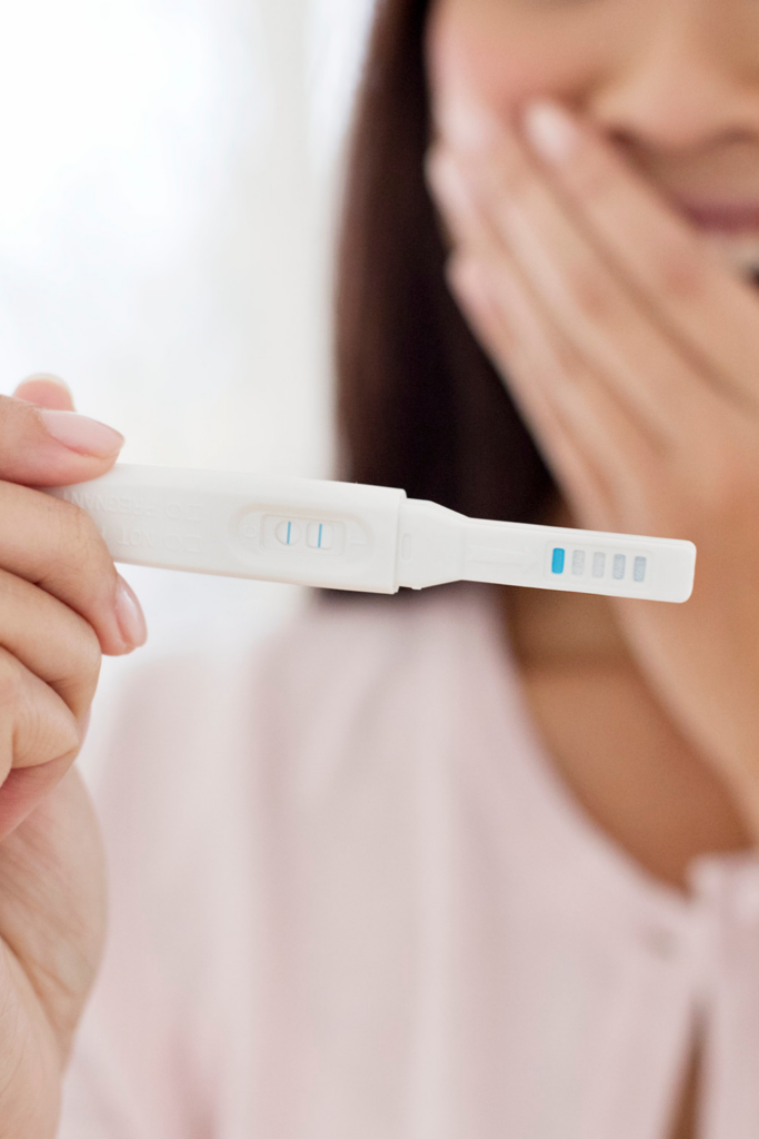 pregnant woman holding positive pregnancy test