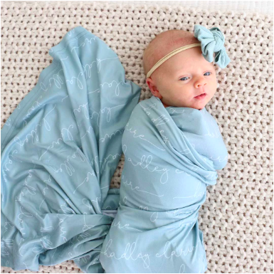 baby girl swaddled in bright blue blanket