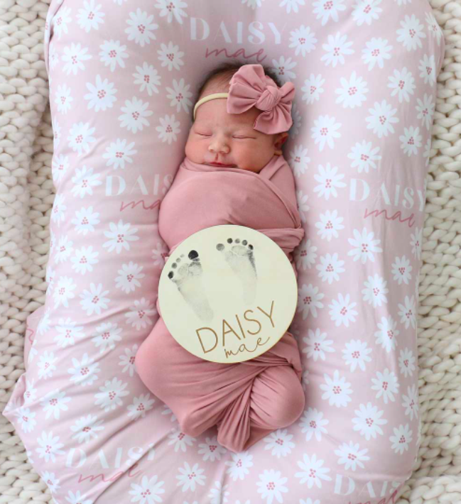 baby girl swaddled in a dusty rose blanket